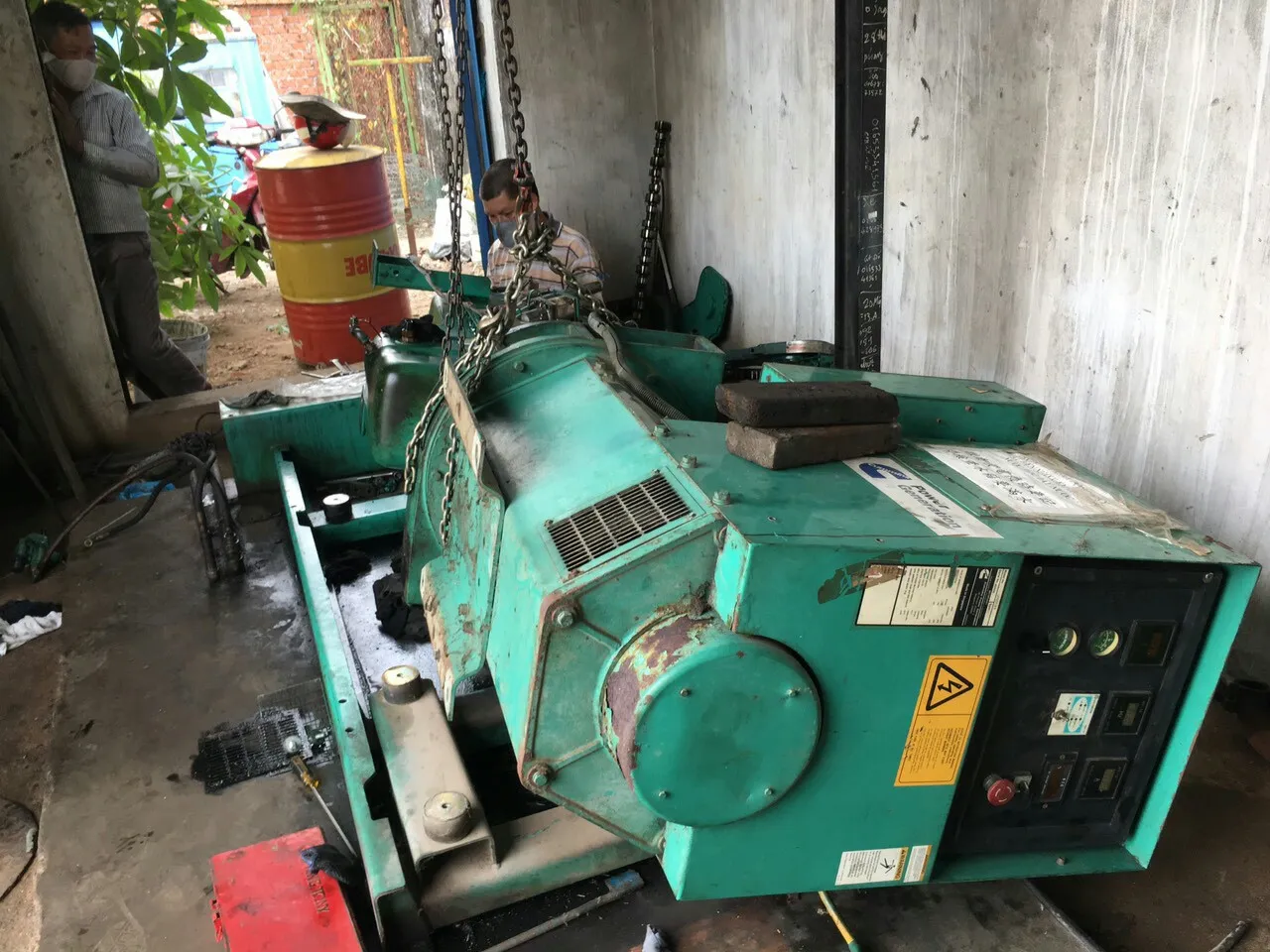 Kỹ thuật viên kiểm tra hệ thống điện máy phát tại xưởng Bình Dương