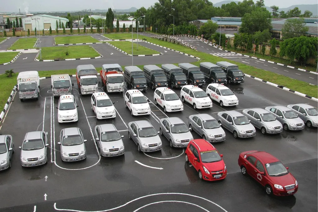 Các thí sinh đang thực hiện phần thi sát hạch thực hành lái xe trong sa hình theo quy định