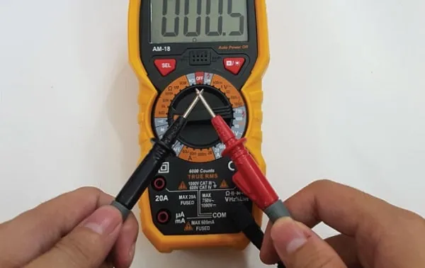 Chạm hai đầu dò của thiết bị đo để đảm bảo độ chính xác trước khi kiểm tra ký hiệu cầu chì trên xe ô tô