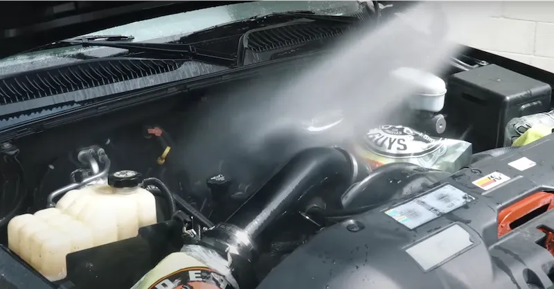 Dùng vòi xịt nước làm sạch lại lần cuối quy trình vệ sinh khoang máy ô tô đúng cách