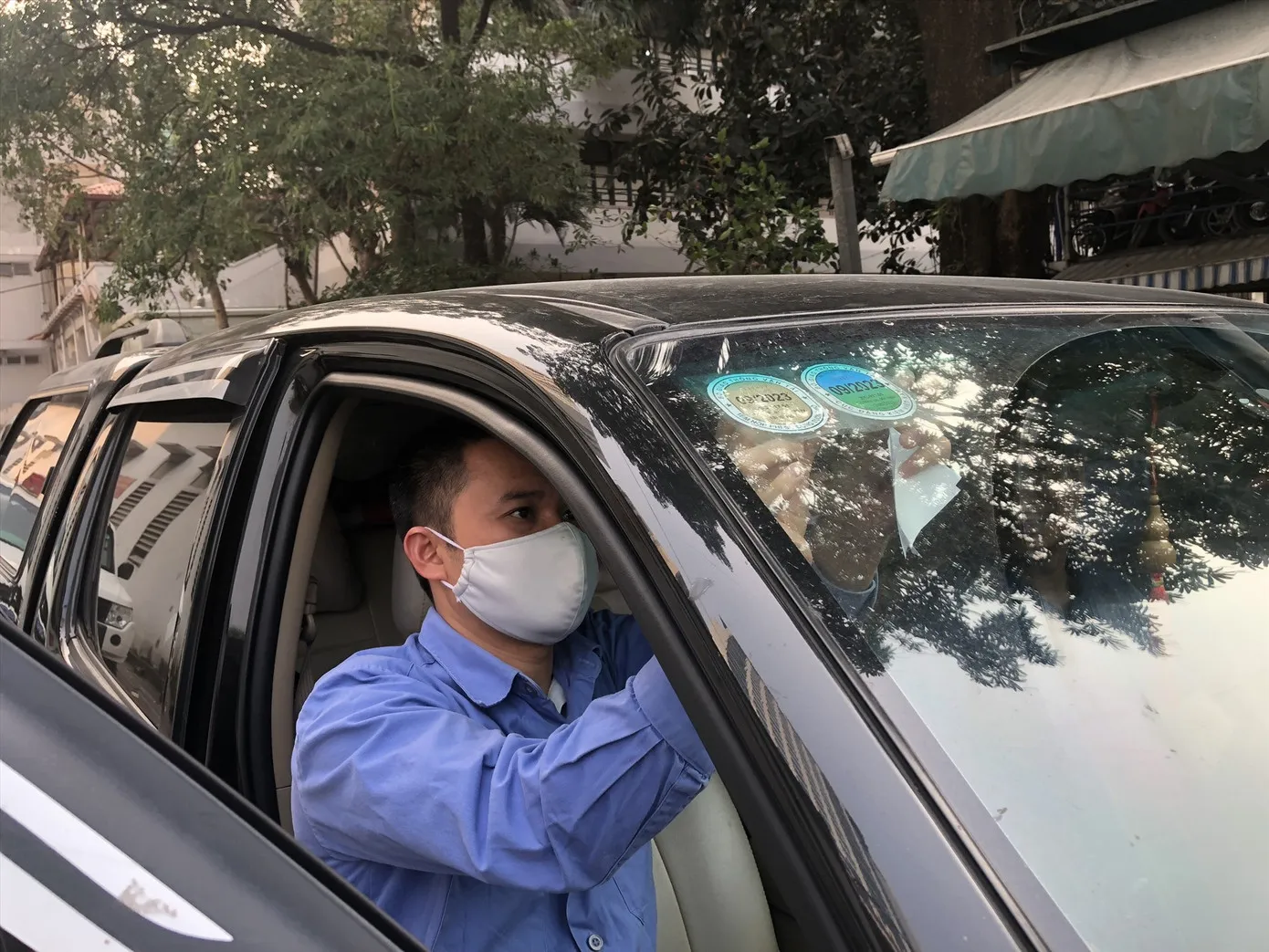 Đăng kiểm viên dán tem kiểm định cho xe. Ảnh: Hữu Chánh.